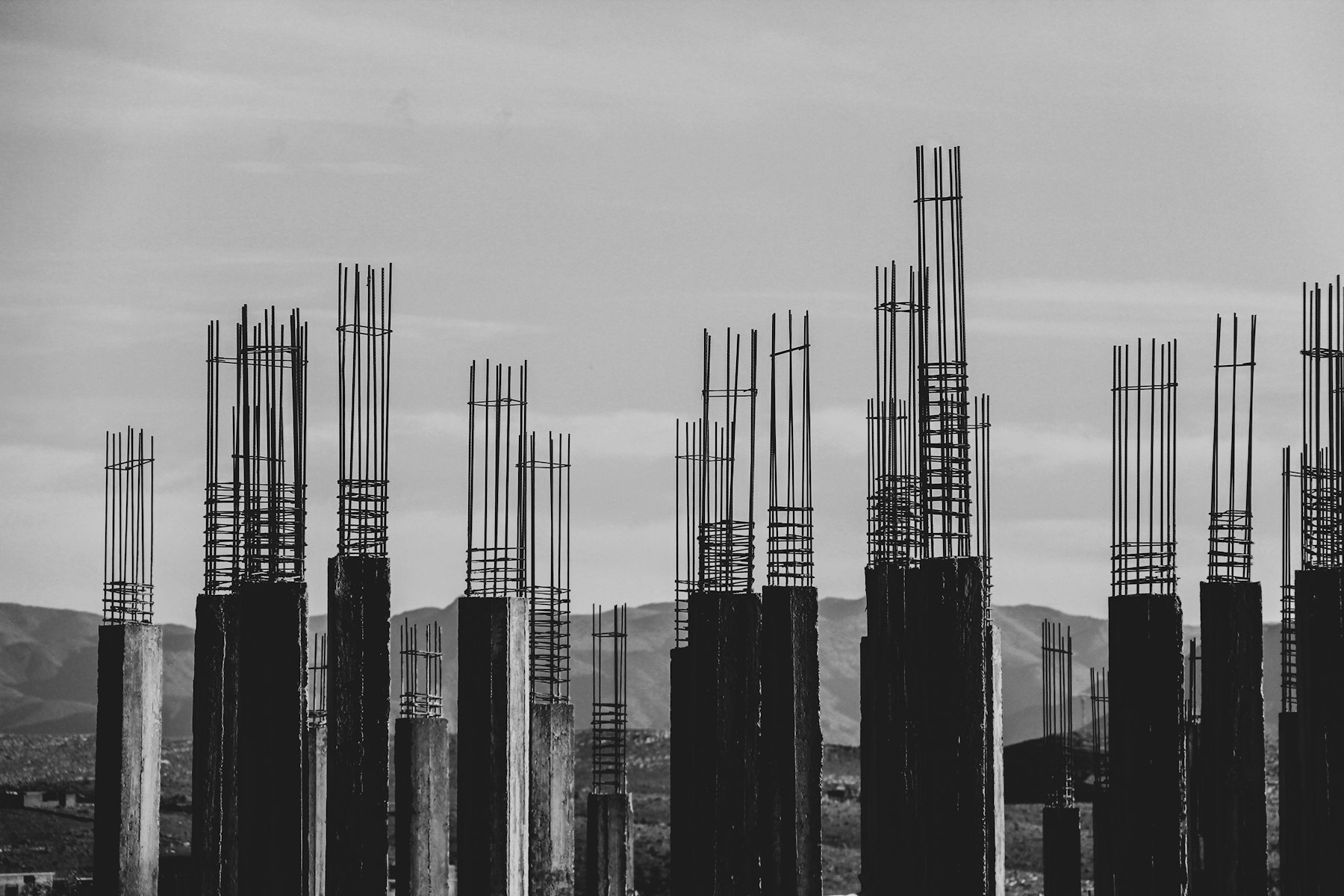Steel reinforcement bars rising from concrete columns